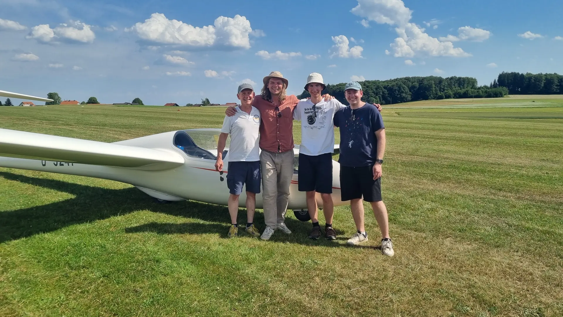 4 Männer stehen vor einem Segelflugzeug