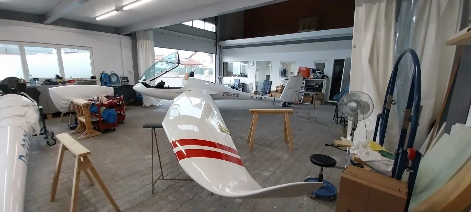 Werkstatt: Flugzeug mit aufgebockter Fläche.
