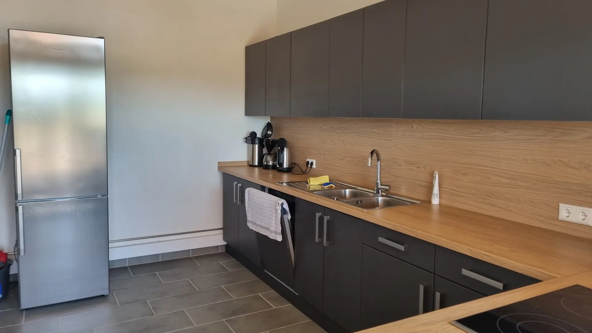 Küche im Vereinsheim mit Kühlschrank, Kaffeemaschinen, Arbeitsfläche und Spüle