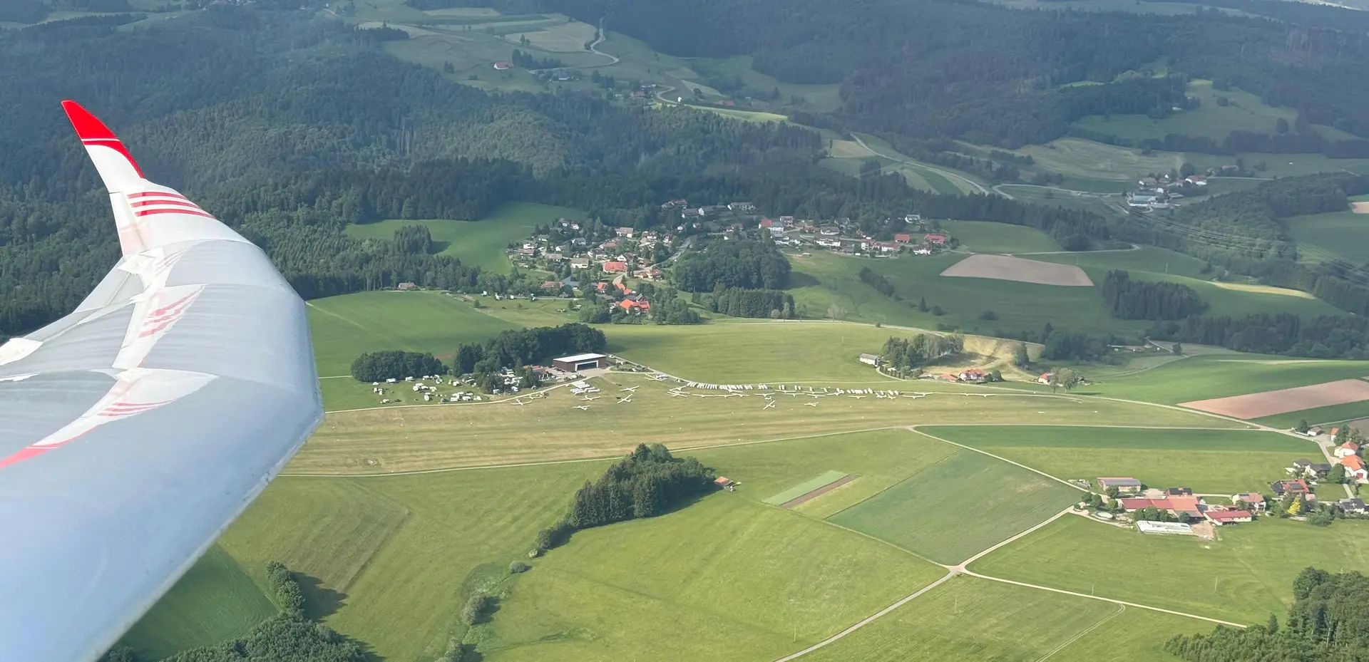 Blick aus dem Cockpit eines Segelflugzeugs über den Flugplatz Hütten-Hotzenwald, vorn die Flügelspitze